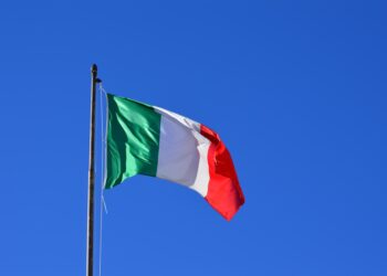 Italian flag flying in the wind against a blue sky