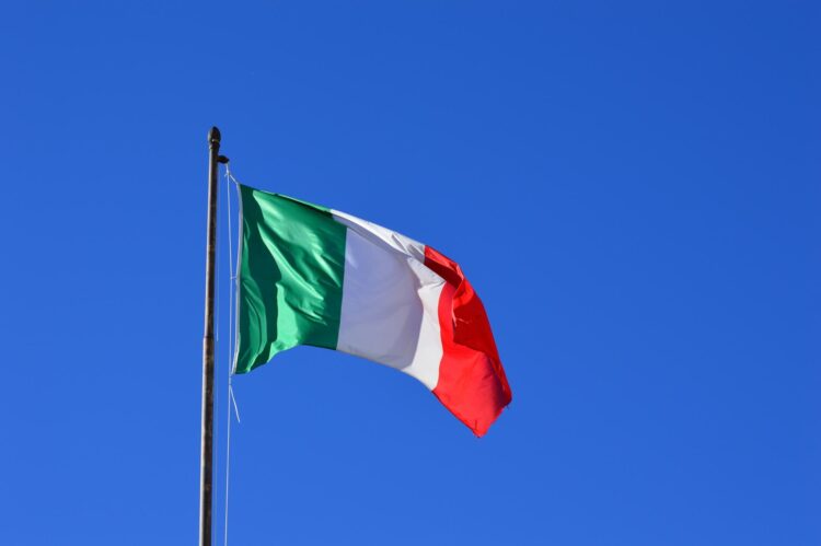 Italian flag flying in the wind against a blue sky