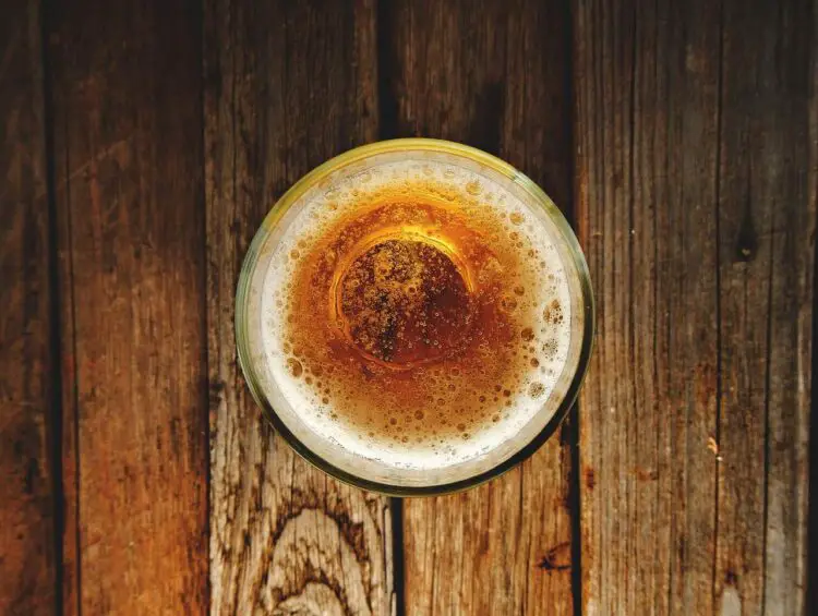 A glass of beer on a wooden table