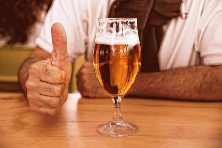 Man drinking and approving of a glass of beer