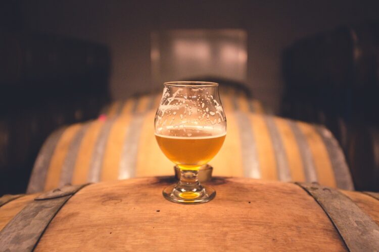 a glass of beer sitting on a cask