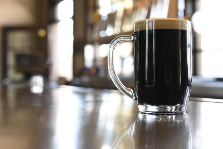 A mug of stout sitting on a bar