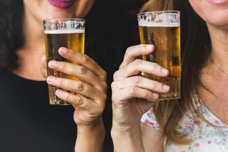 Two women drinking pints of beer